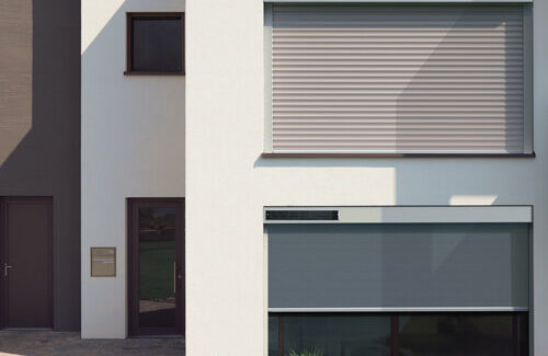 Rollladen mit Solarmodulen an der weißen Fassade eines Hauses